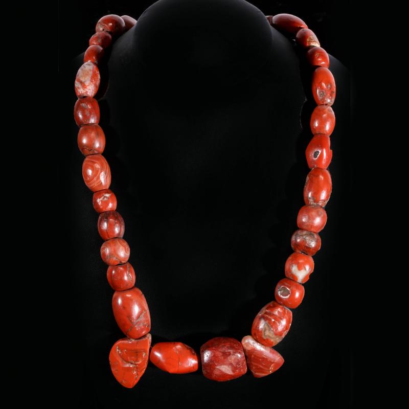 A STRAND OF PRIMITIVE BRECCIATED JASPER BEADS