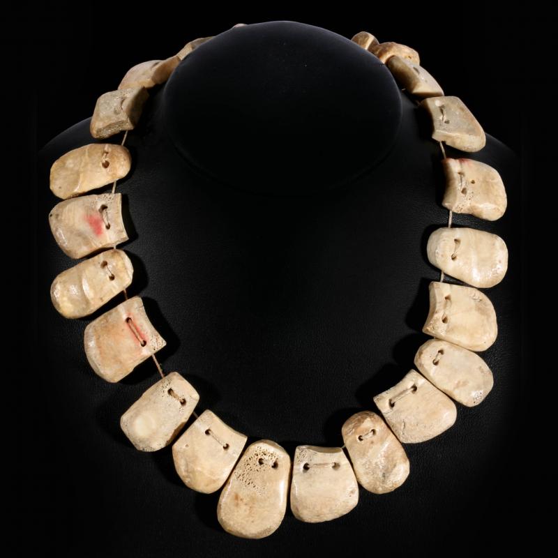 A NECKLACE OF TWENTY-TWO CARVED BONE 'ELK TEETH'  