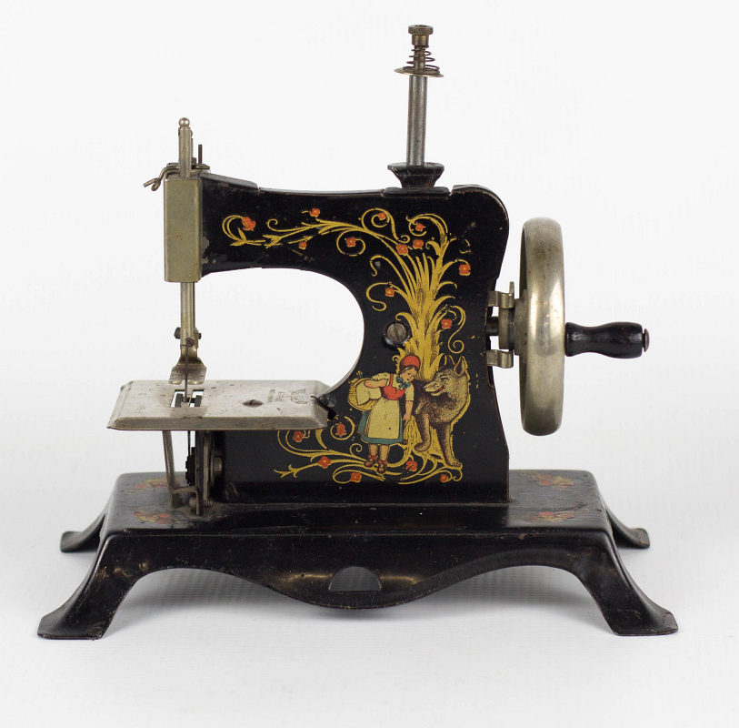 A GERMAN MINIATURE TIN LITHO SEWING MACHINE