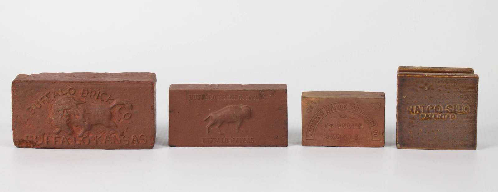 FOUR BRICK AND VITRIFIED ADVERTISING PAPERWEIGHTS