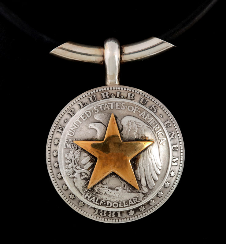 AN ARNOLD GOLDSTEIN DOMED SILVER DOLLAR PENDANT