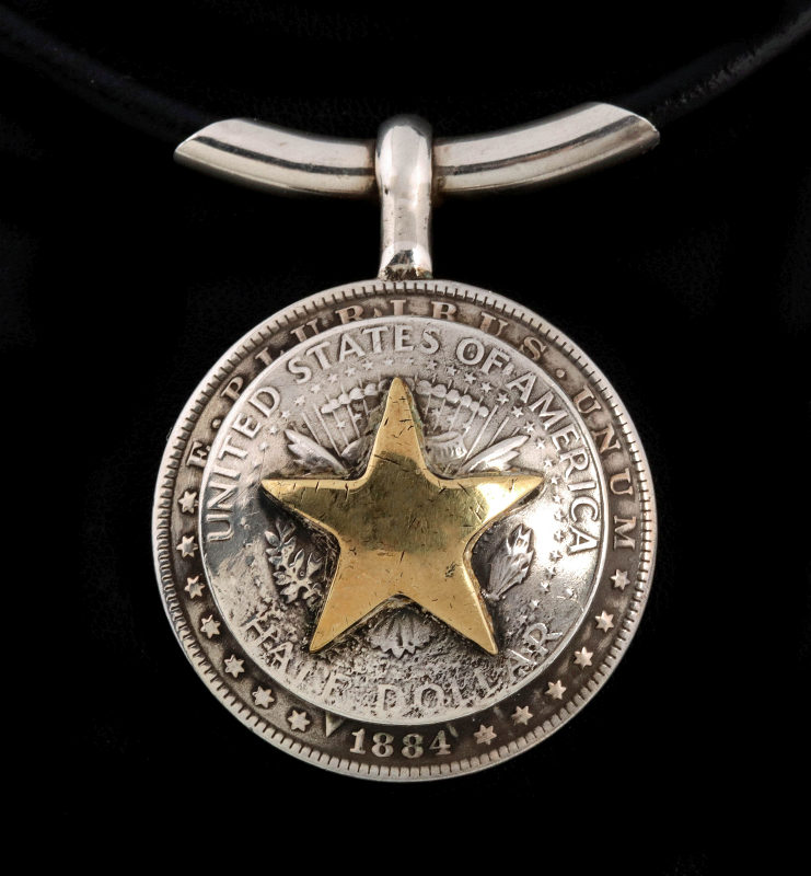 AN ARNOLD GOLDSTEIN DOMED SILVER DOLLAR PENDANT