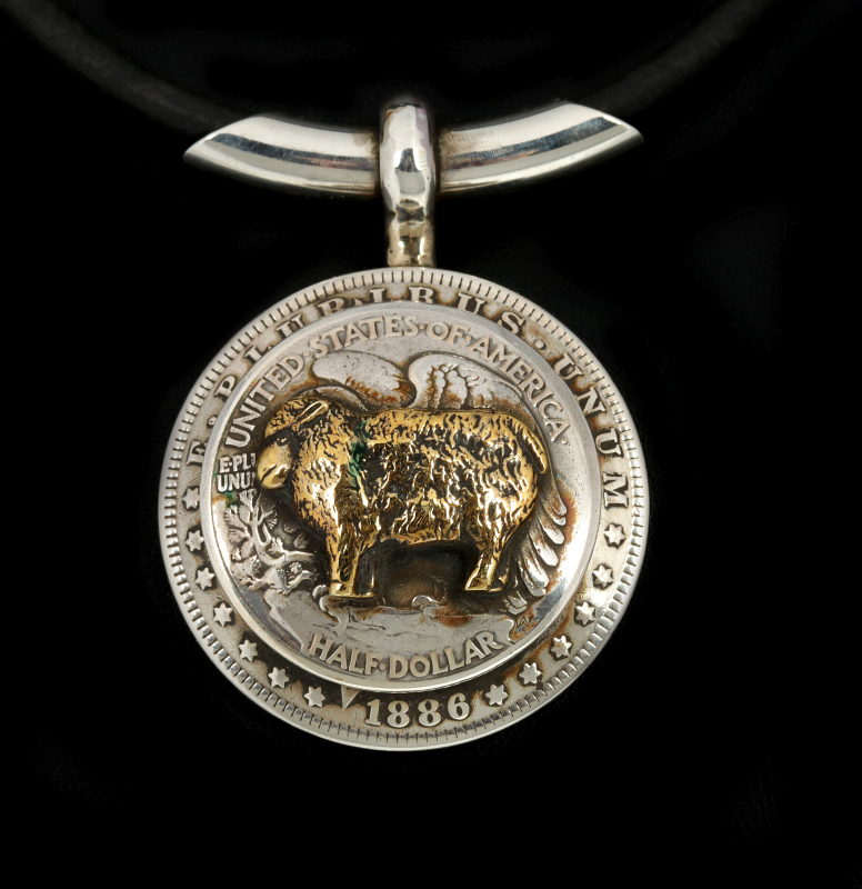 AN ARNOLD GOLDSTEIN DOMED SILVER DOLLAR PENDANT