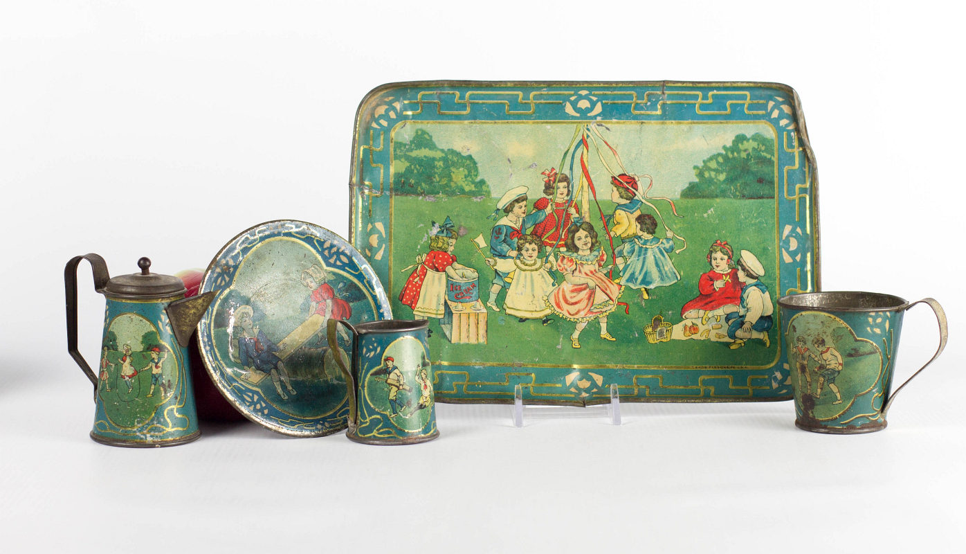 A TIN LITHO CHILD'S TEA SET w/ CHILDREN PLAYING