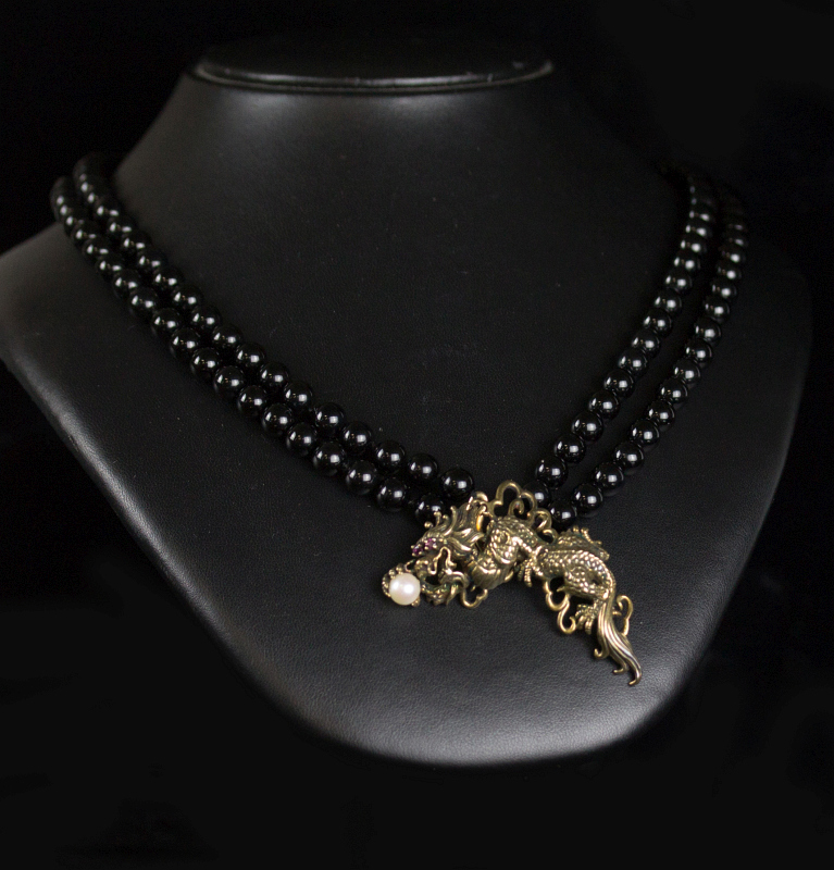 A VERMEIL FIGURAL DRAGON PENDANT ON ONYX BEADS