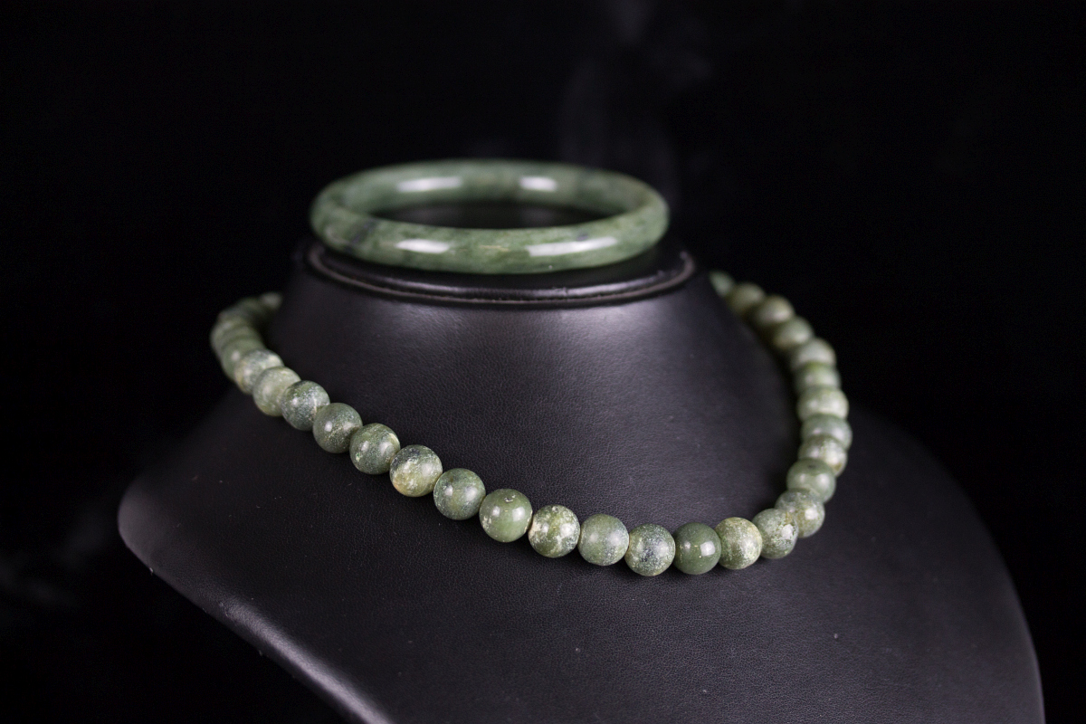 A JADE BANGLE BRACELET AND STRAND OF BEADS