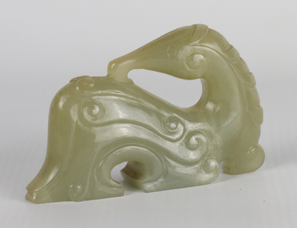 A CHINESE CARVED JADE STYLIZED SHISHI FIGURE