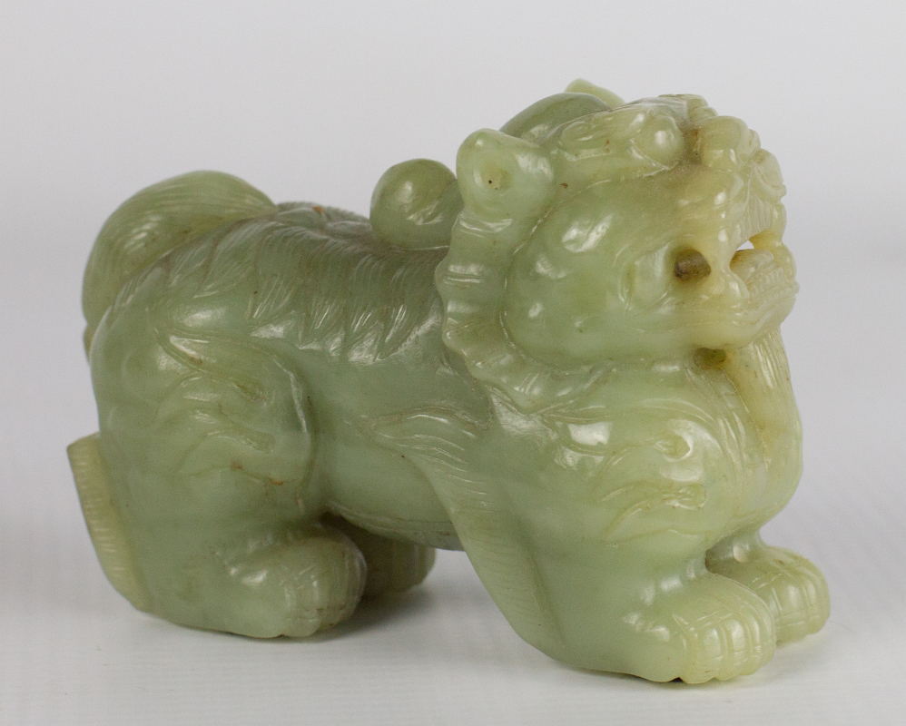 A CHINESE CARVED JADE FOO DOG FIGURE 