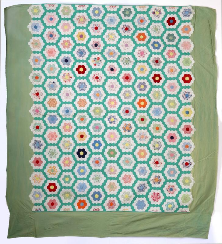 A 'GRANDMOTHER'S FLOWER GARDEN' FEEDSACK QUILT