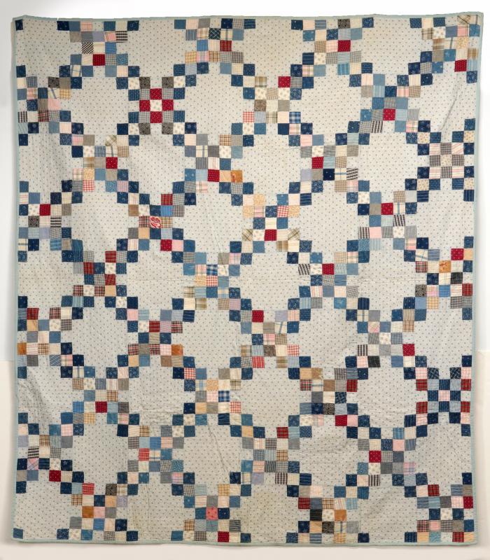 A 'TRIPLE IRISH CHAIN' ANTIQUE QUILT