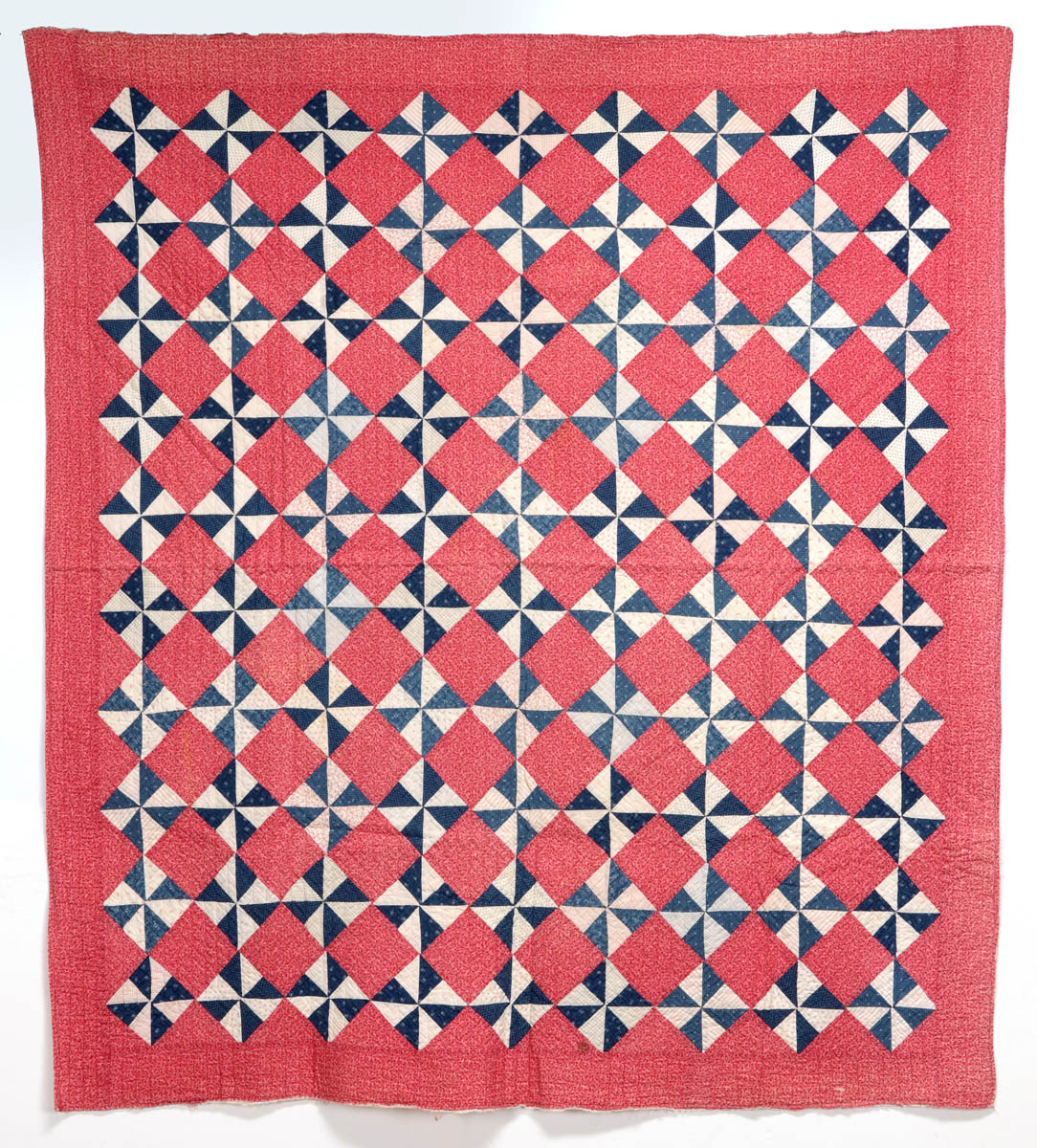 A 'PINWHEEL' PATTERN ANTIQUE QUILT