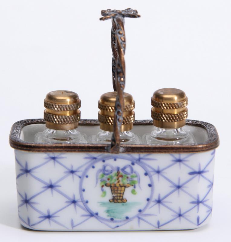 A LIMOGES PORCELAIN BASKET WITH MINIATURE PERFUMES
