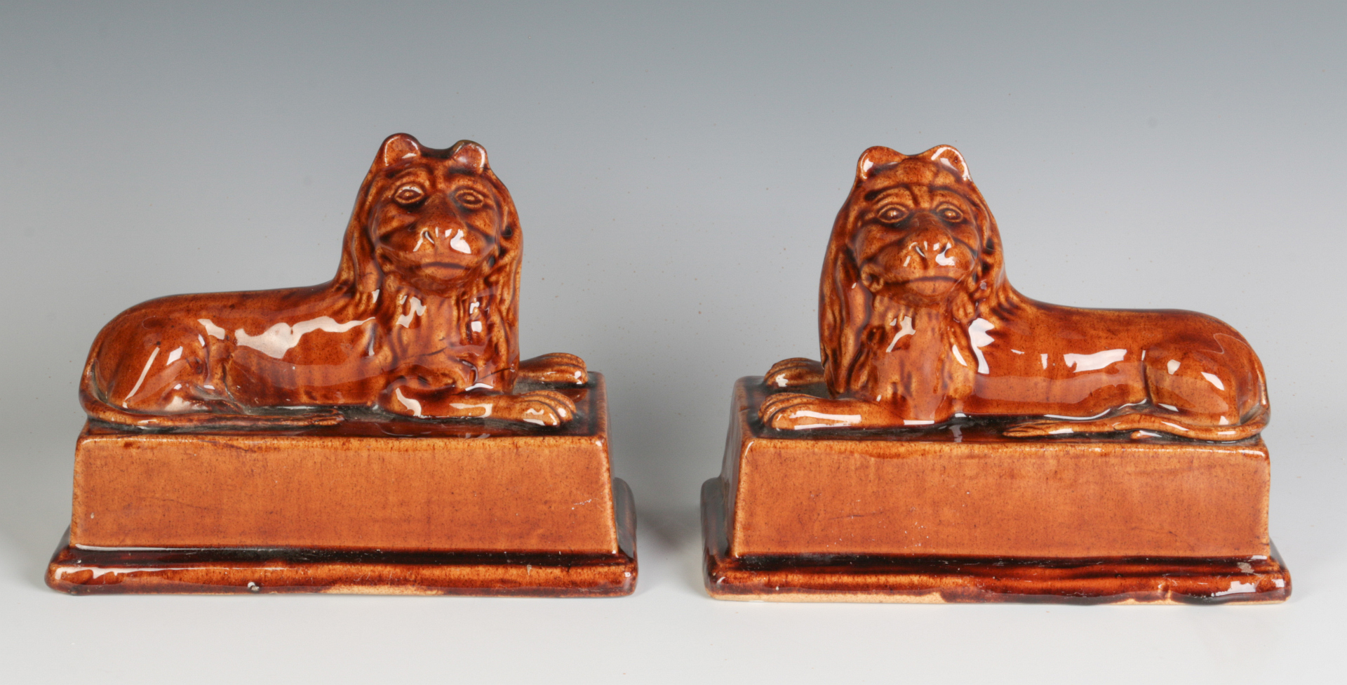 A PAIR BRITISH STONEWARE RECUMBENT LION FIGURES