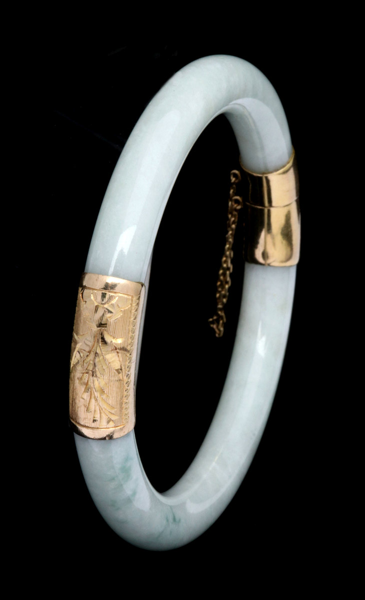 A LIGHT GREEN JADE AND 14K GOLD BANGLE BRACELET