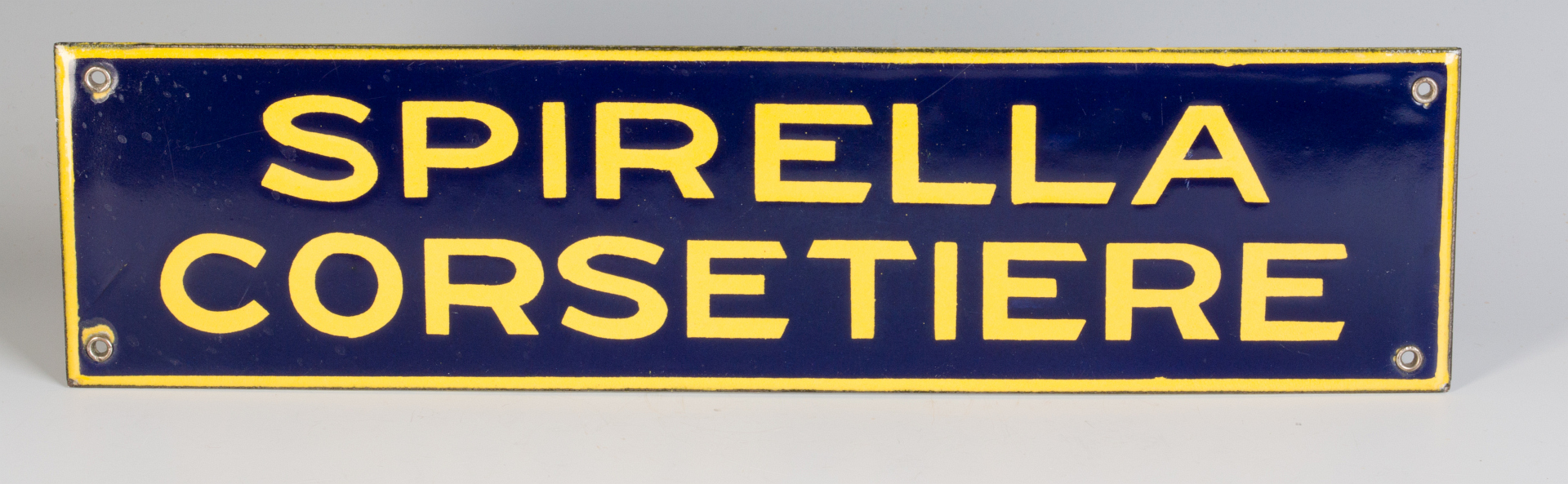 A PORCELAIN ENAMEL SIGN FOR SPIRELLA CORSETIERE