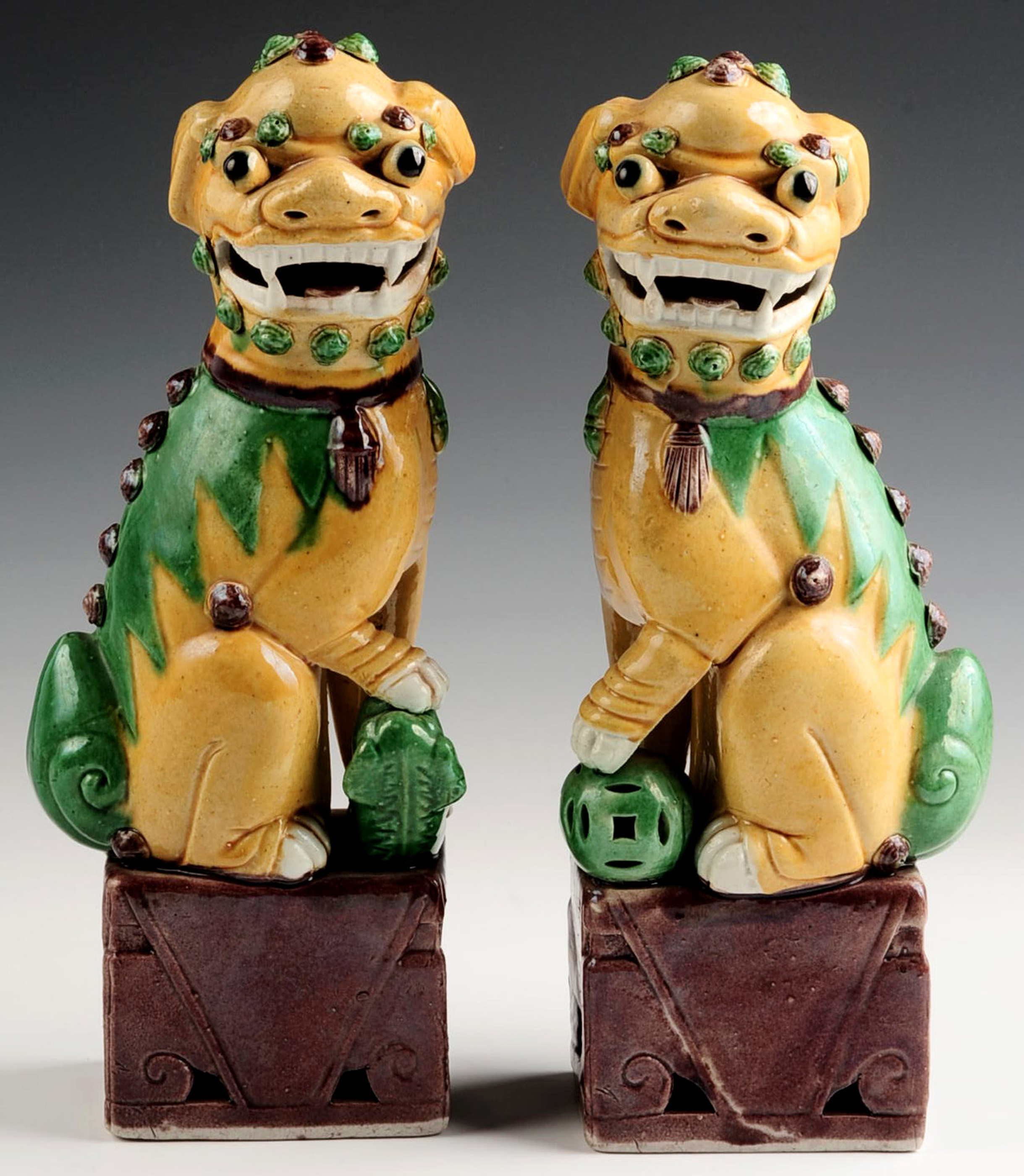 A PAIR OF EARLY 20TH CENTURY GLAZED FOO DOG FIGURE