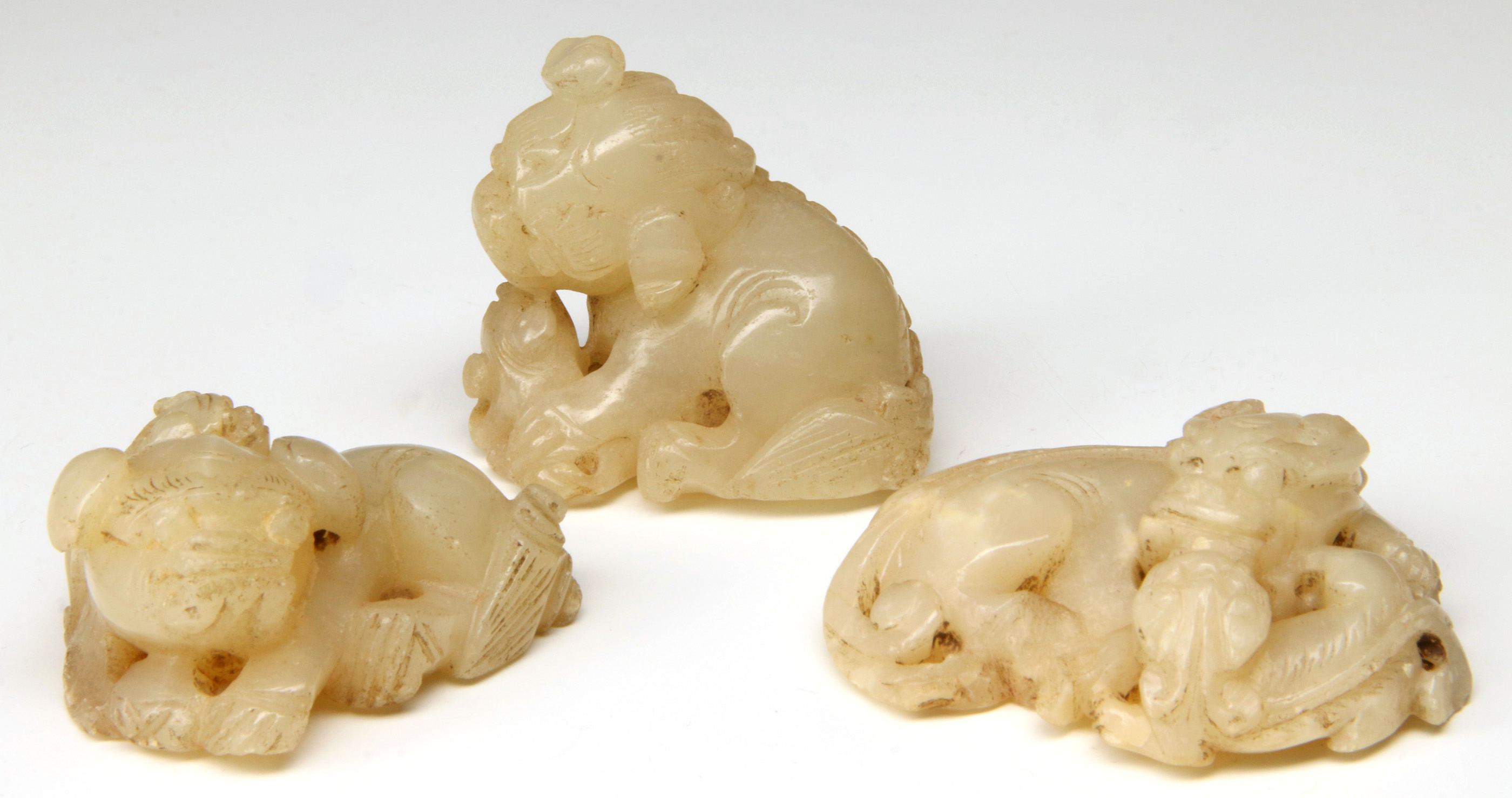 THREE CHINESE CARVED WHITE JADE FU DOGS