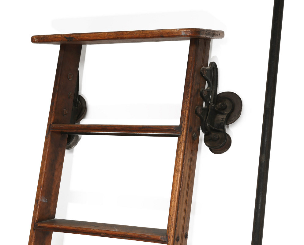 A CIRCA 1890s OAK LIBRARY LADDER WITH RAIL