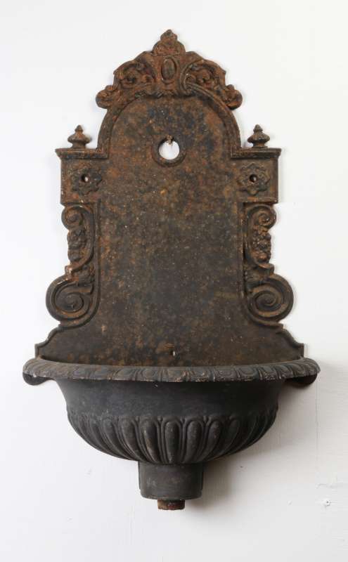 AN ANTIQUE CAST IRON WALL FOUNTAIN BASIN