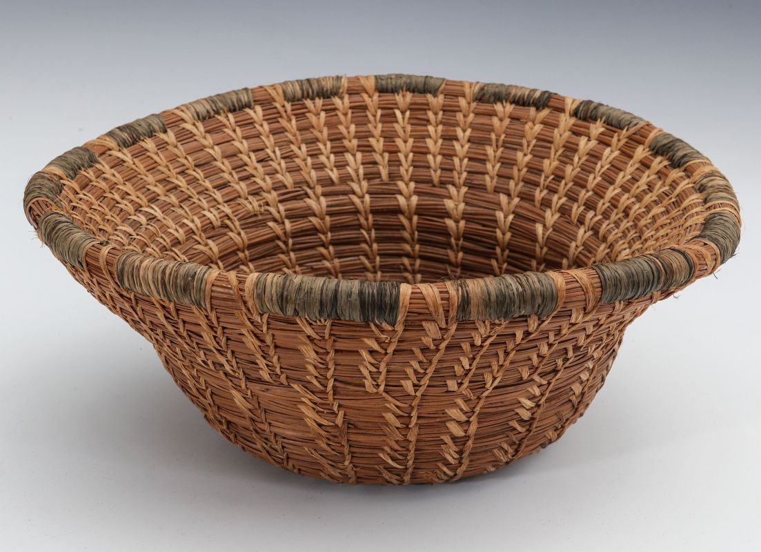 A PINE NEEDLE BASKET WITH BIRCH BARK