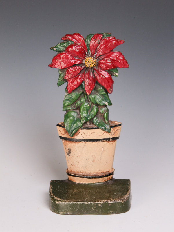 AN EARLY 20TH C. POINSETTIA CAST IRON DOOR STOP