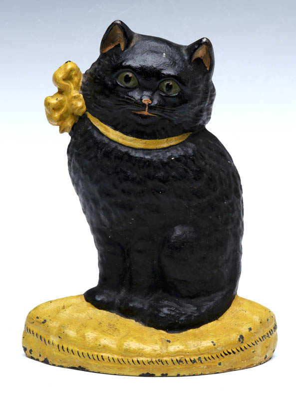 A CAST IRON KITTEN ON A CUSHION DOORSTOP