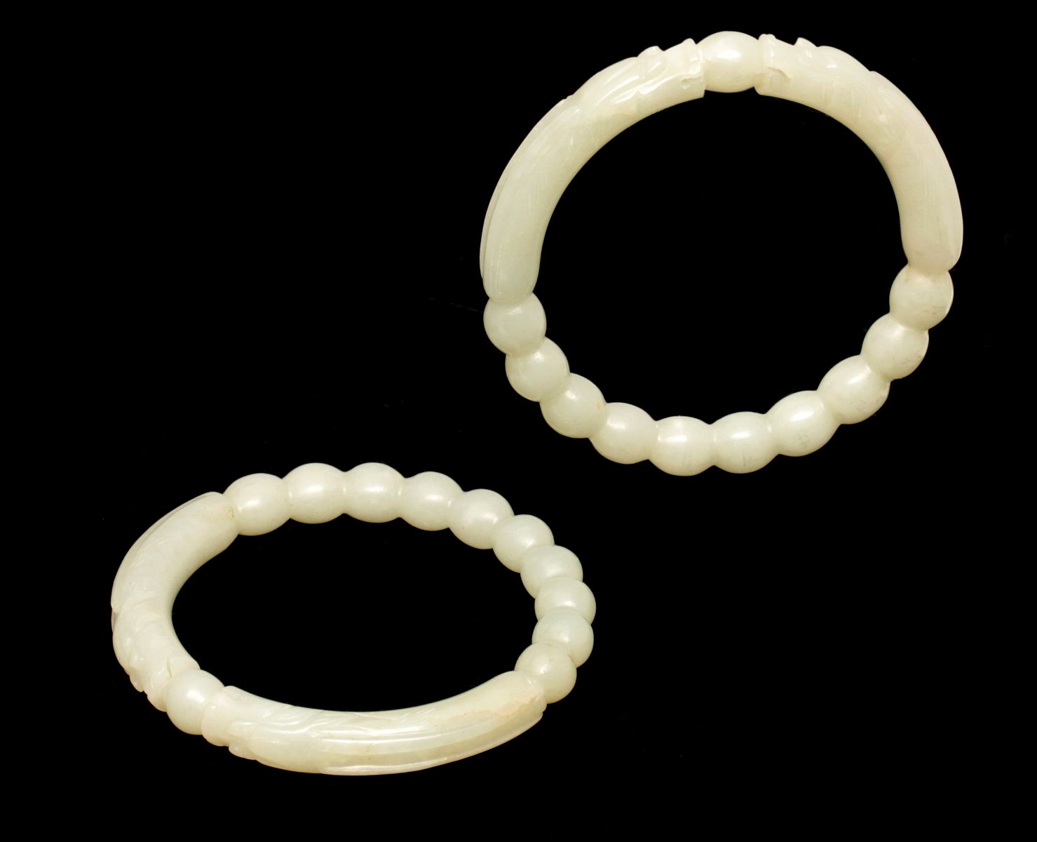 A PAIR OF CARVED JADE BRACELETS