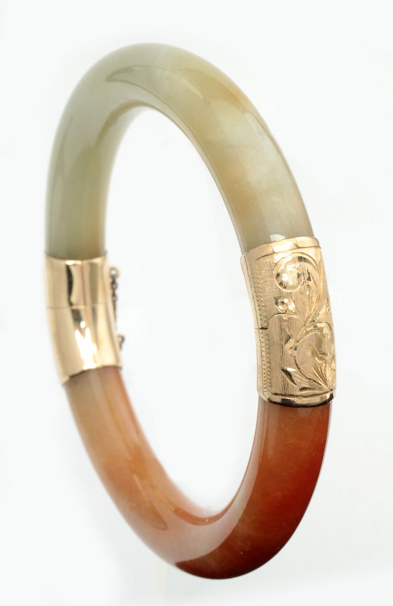 A JADE BANGLE BRACELET WITH 14K YELLOW GOLD MOUNTS