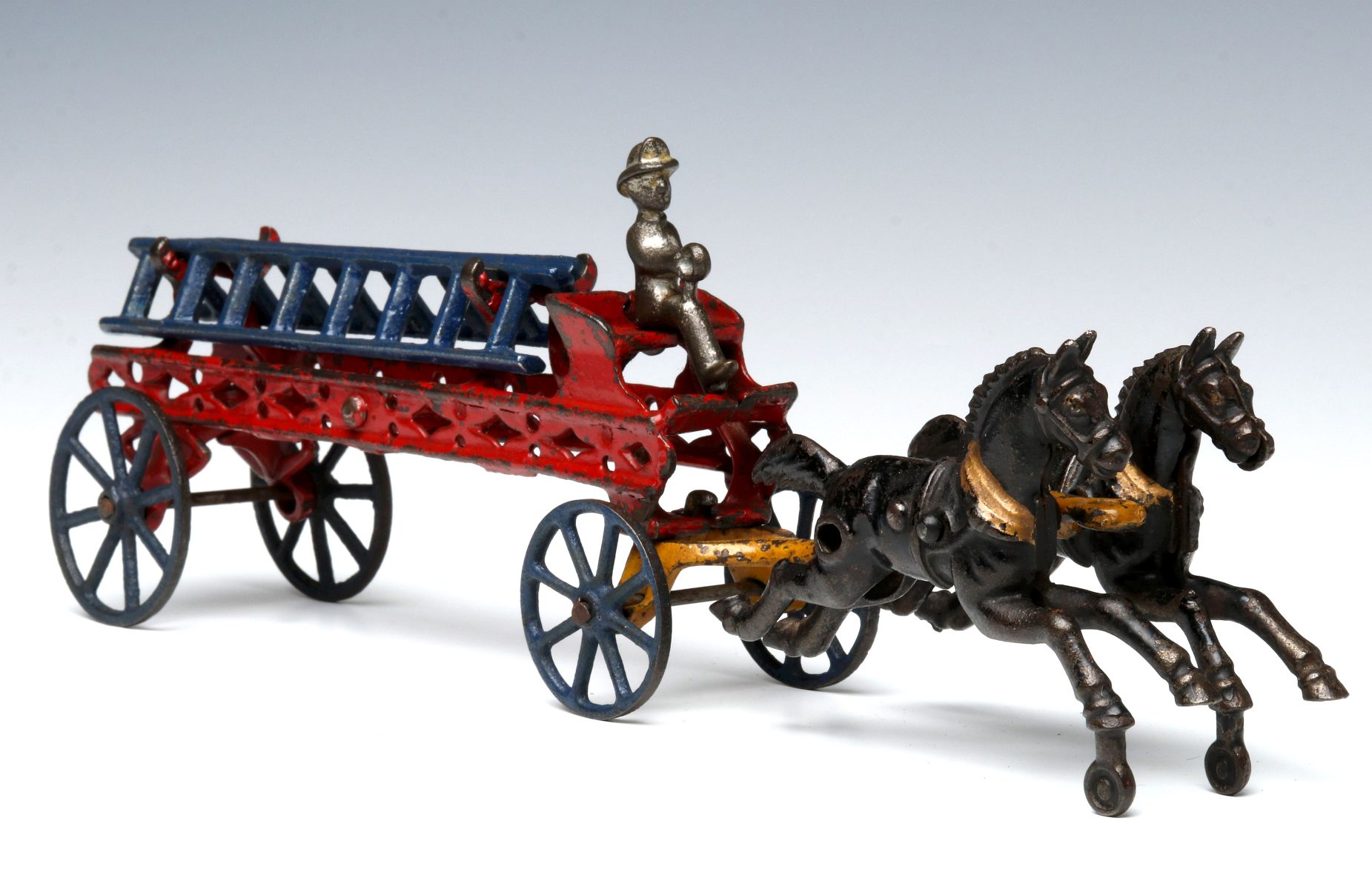 A CAST IRON HORSE DRAWN FIREFIGHTING LADDER WAGON