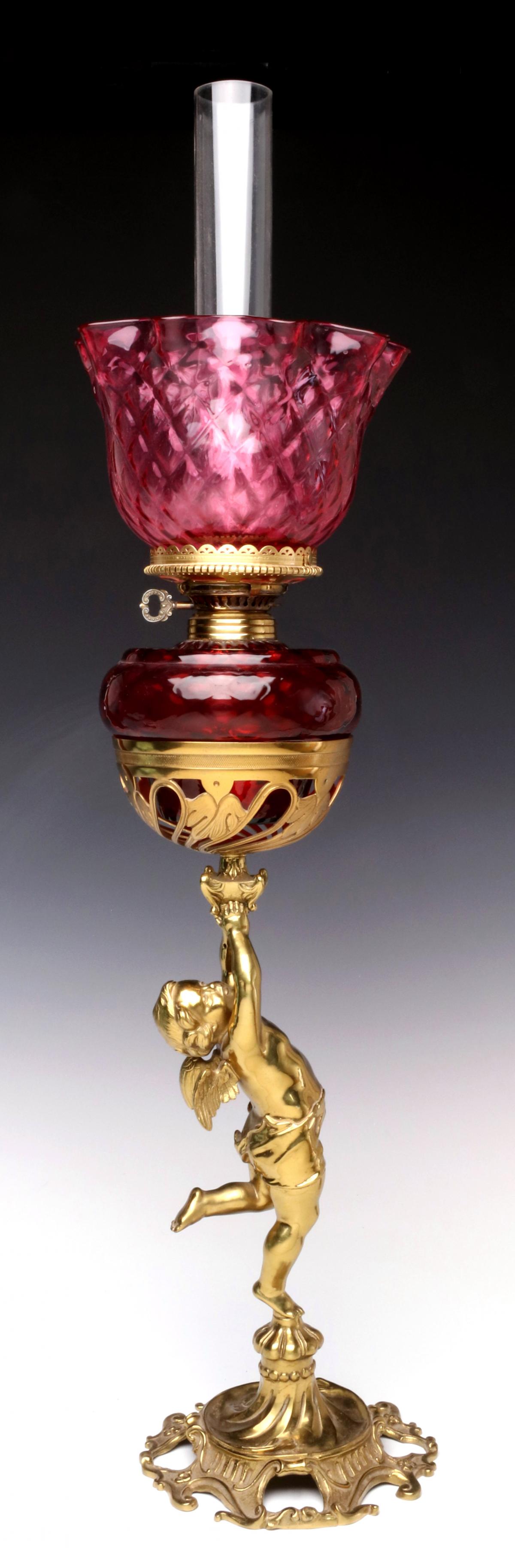 A CHERUB FIGURAL BRASS BASE WITH CRANBERRY LAMP