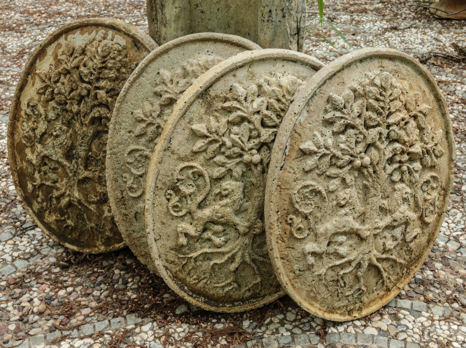 FOUR DECORATIVE CAST CONCRETE ROUNDELS