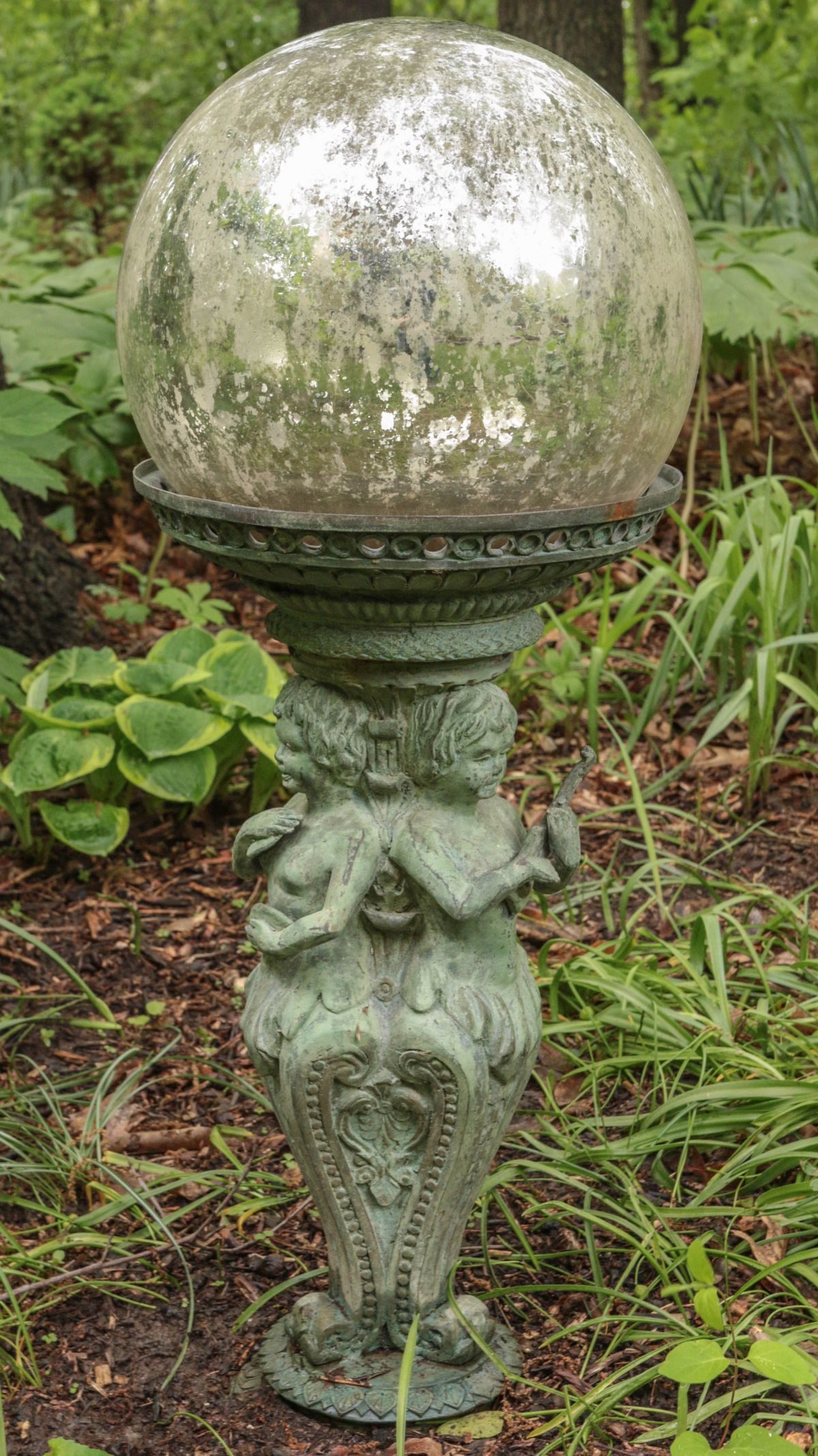 A VERDIGRIS BRONZE GARDEN STATUE WITH GAZING BALL