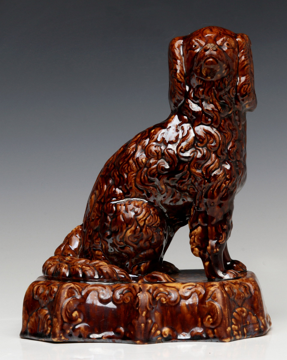 A 19TH CENTURY BENNINGTON TYPE SPANIEL FIGURE