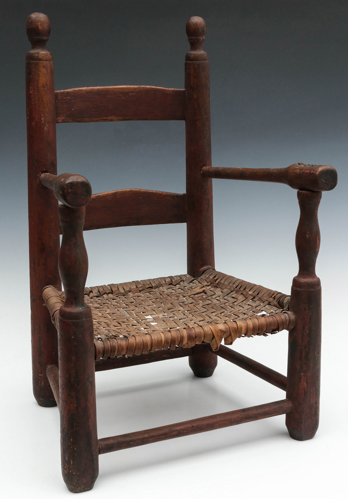 AN EARLY LADDER BACK CHILD'S CHAIR IN OLD RED PAINT