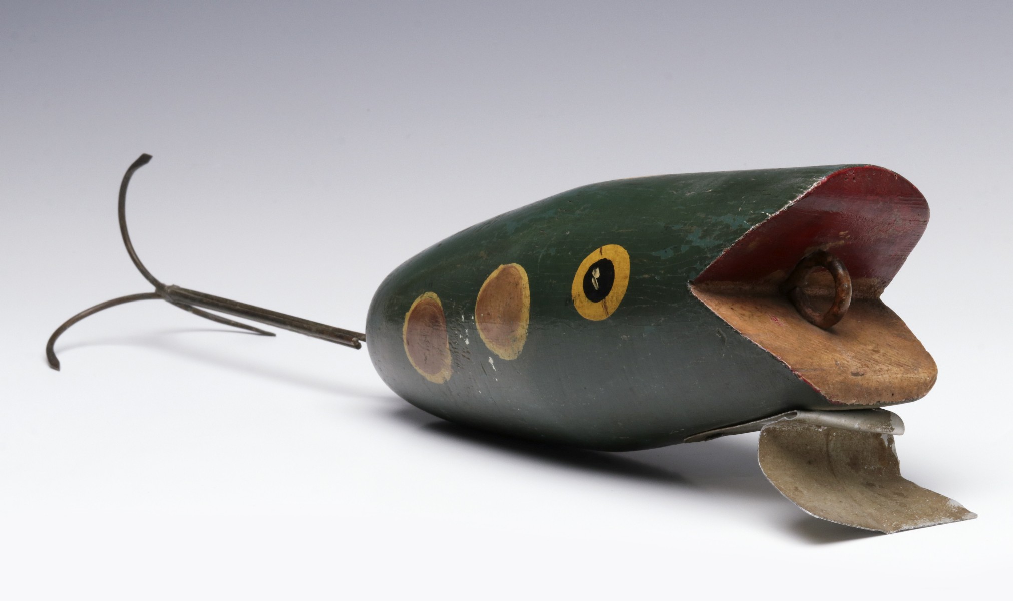 AN OVERSIZED CARVED AND PAINTED WOOD FISHING PLUG