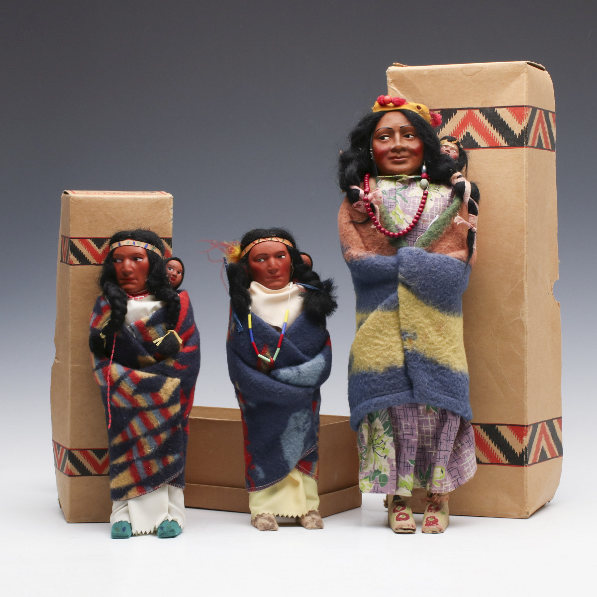 THREE SKOOKUM INDIAN DOLLS WITH THEIR ORIGINAL BOXES