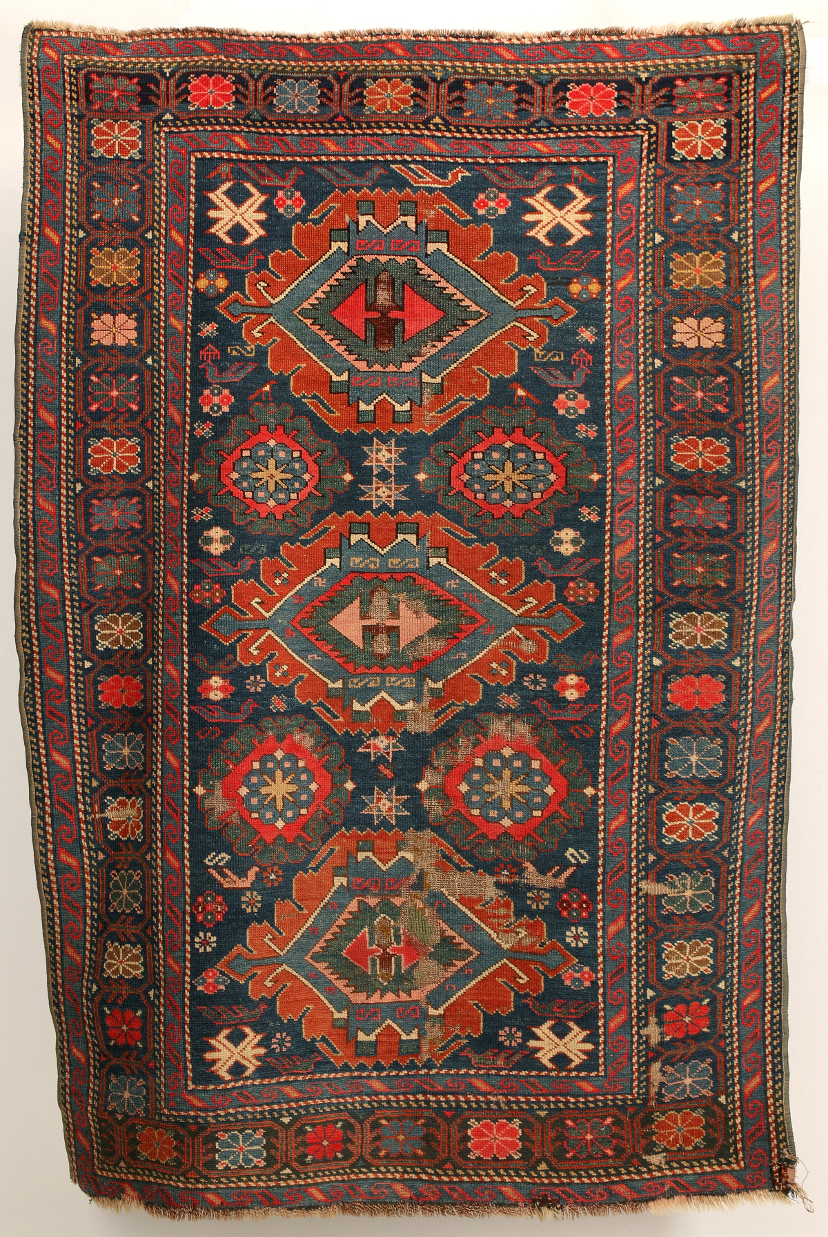 AN ANTIQUE CAUCASIAN SCATTER RUG