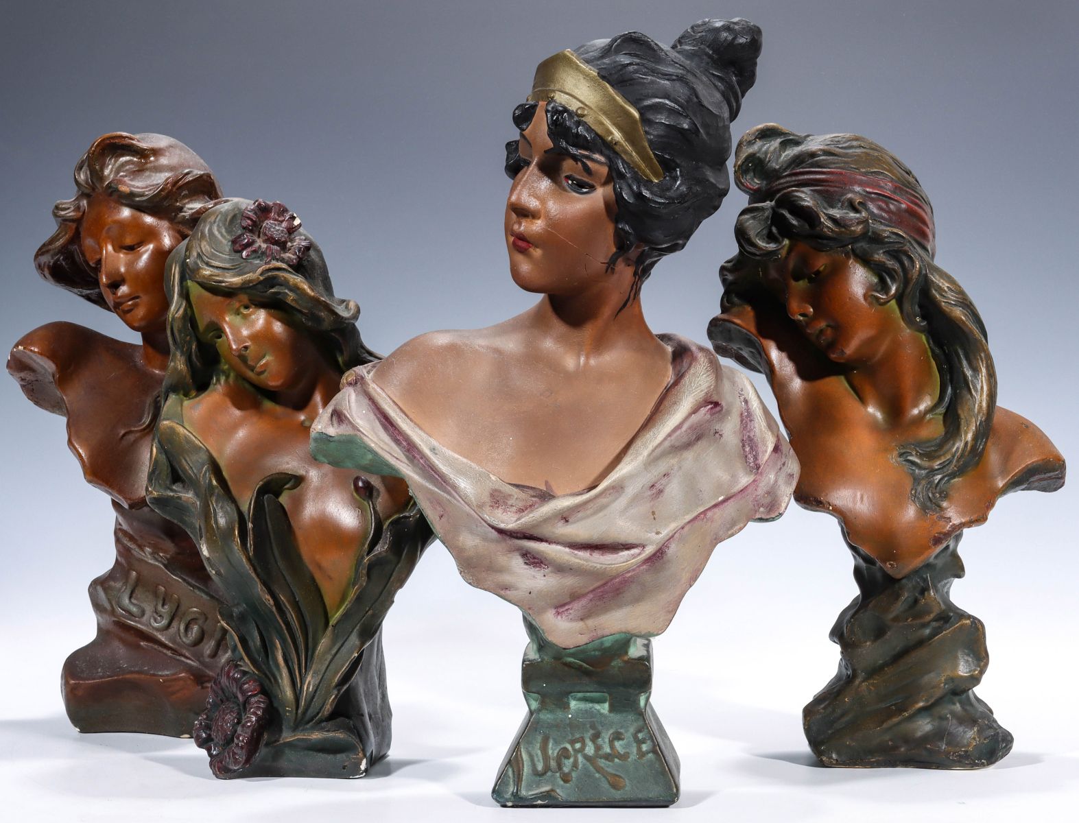 FOUR POLYCHROME ENAMEL PLASTER MAIDEN BUST FIGURES