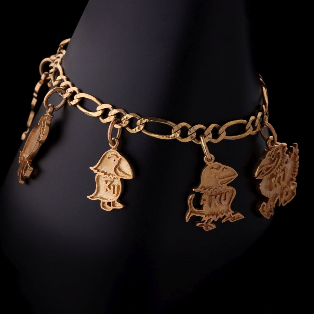 A 14K GOLD BRACELET WITH SIX K.U. JAYHAWK CHARMS