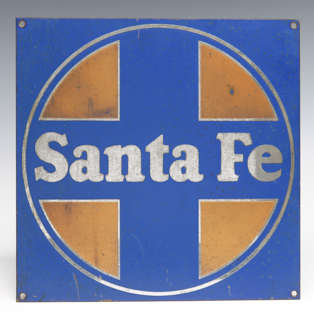 A MID 20TH C. ENAMELED BRASS OR BRONZE SANTA FE LOGO