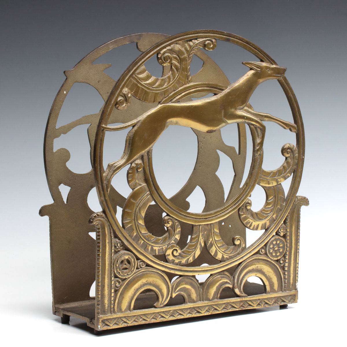 A CLASSIC ART DECO CAST BRASS MAGAZINE RACK WITH HOUNDS