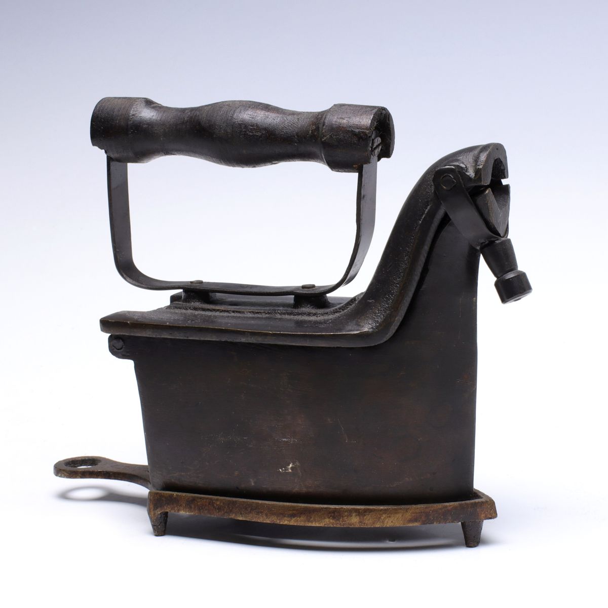 AN ALBA CHARCOAL IRON WITH MATCHING TRIVET