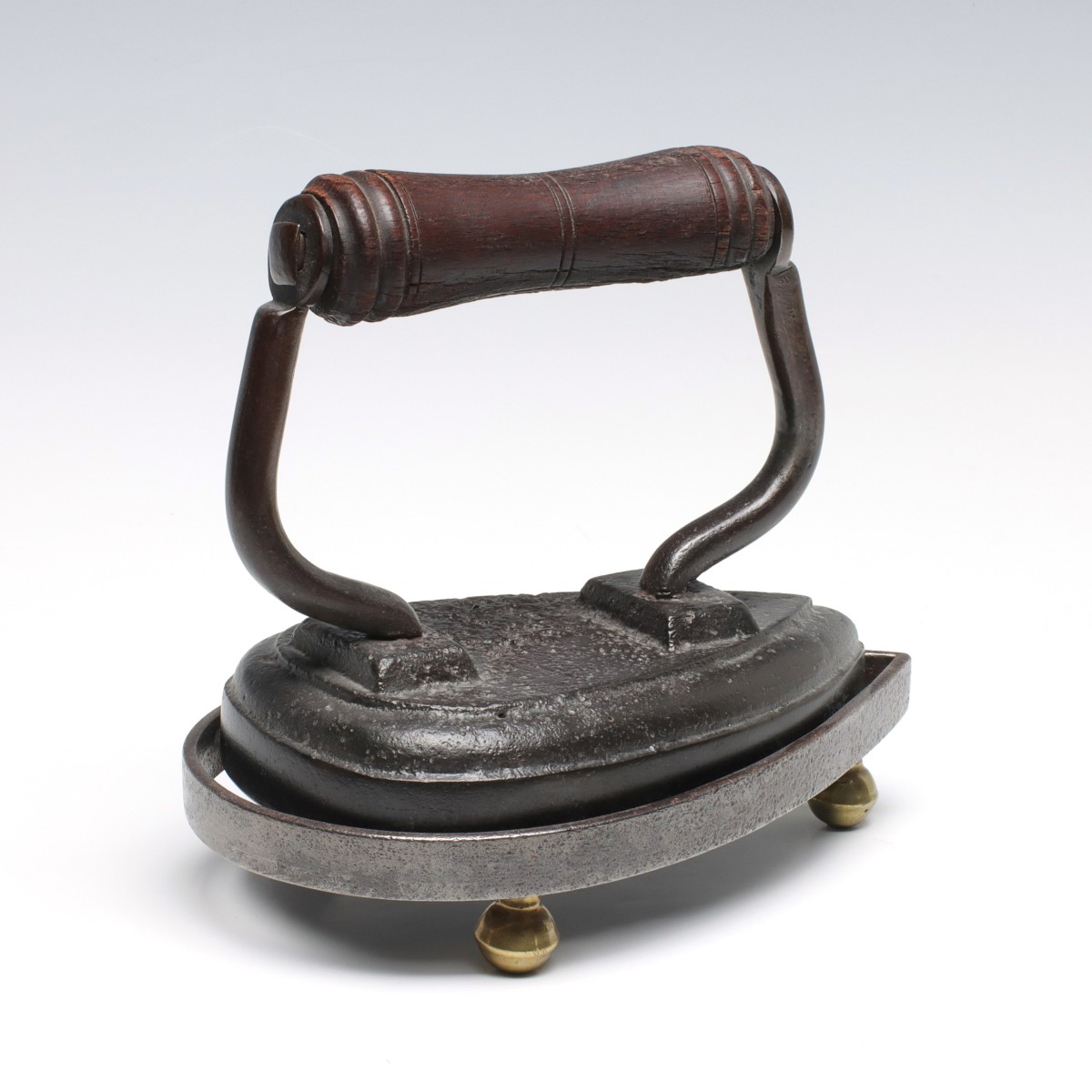 AN UNUSUAL SAD IRON WITH MATCHING TRIVET
