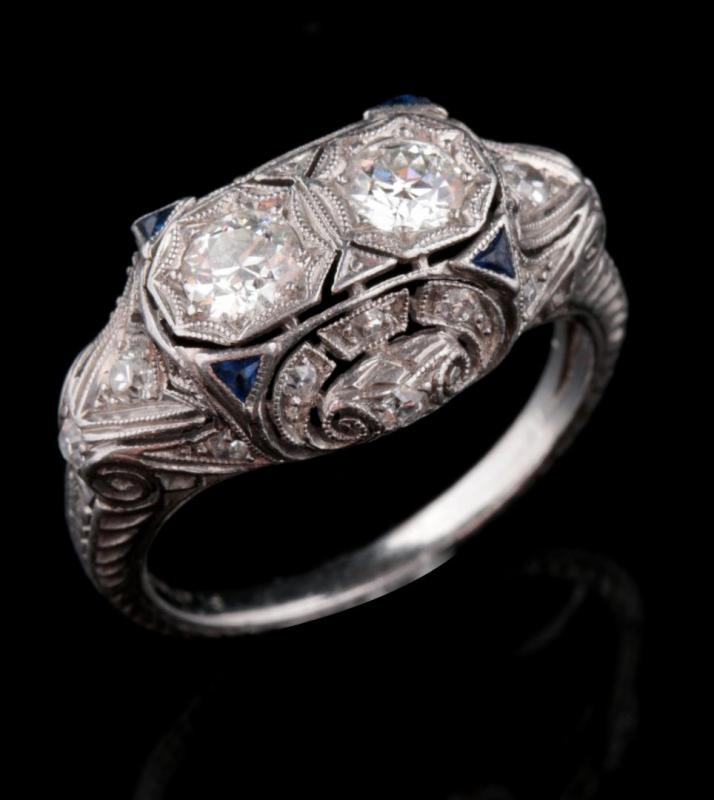 A 1930S PLATINUM DIAMOND AND SAPPHIRE SCROLL RING 