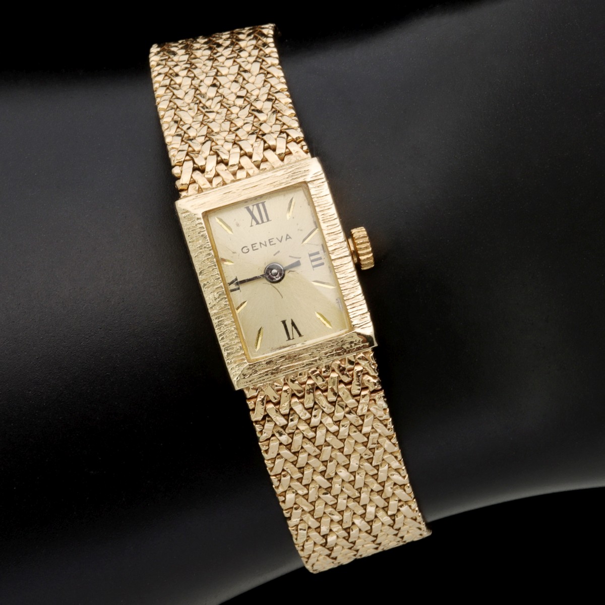 A GENEVA LADIES 14 KARAT GOLD WATCH AND BAND