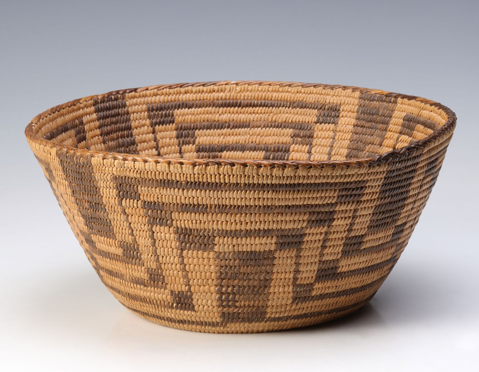 A PIMA COILED BASKET WITH STEPPED GEOMETRIC DESIGN