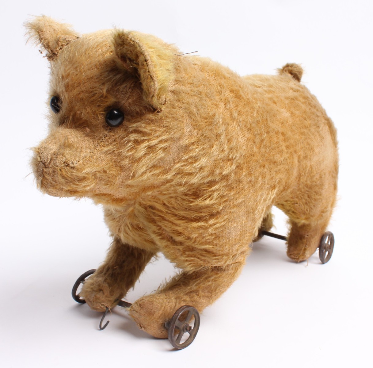 AN EARLY GOLD MOHAIR BEAR ON IRON WHEELS