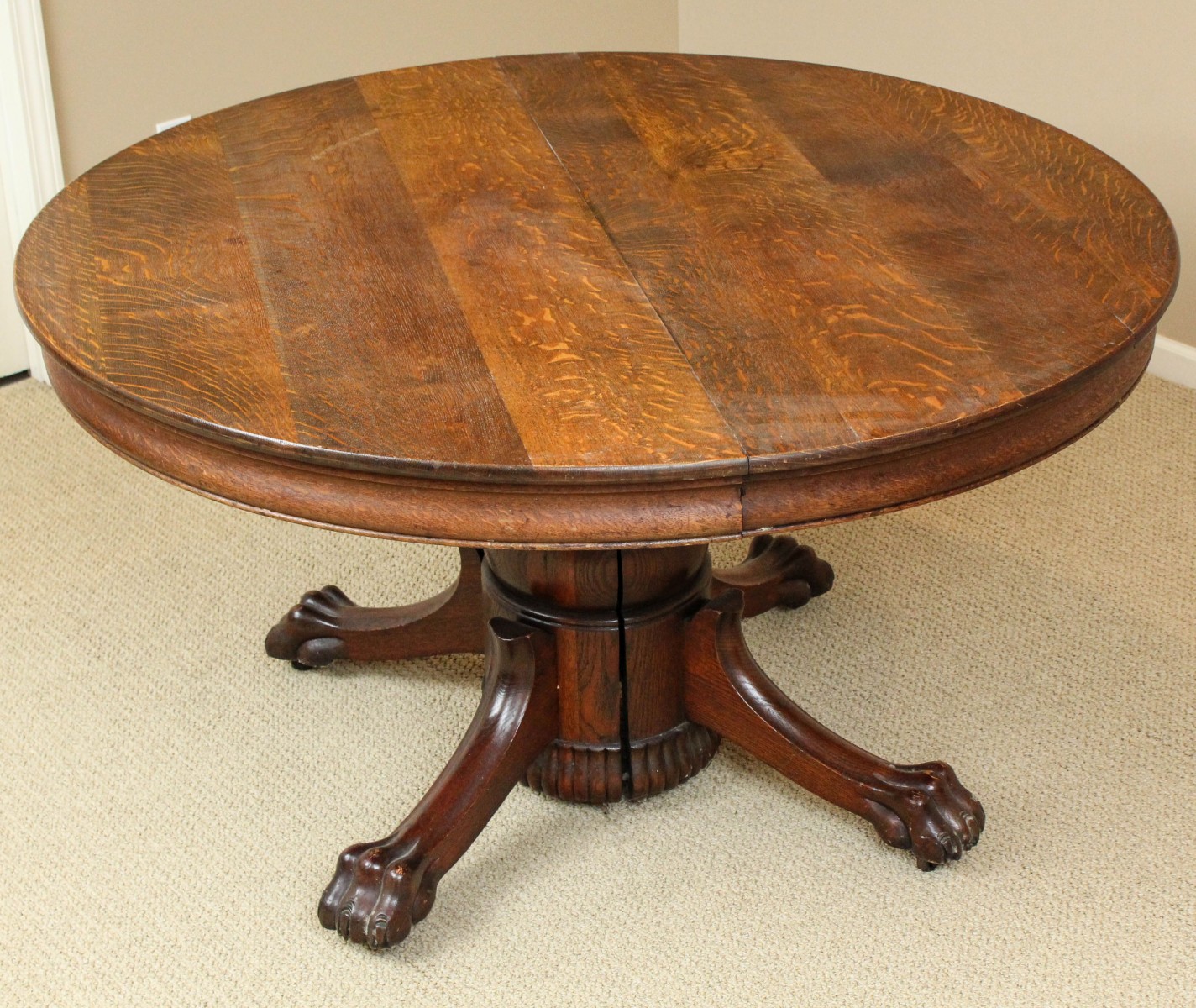 A CIRCA 1900 ROUND OAK TABLE WITH LARGE CARVED PAW FEET