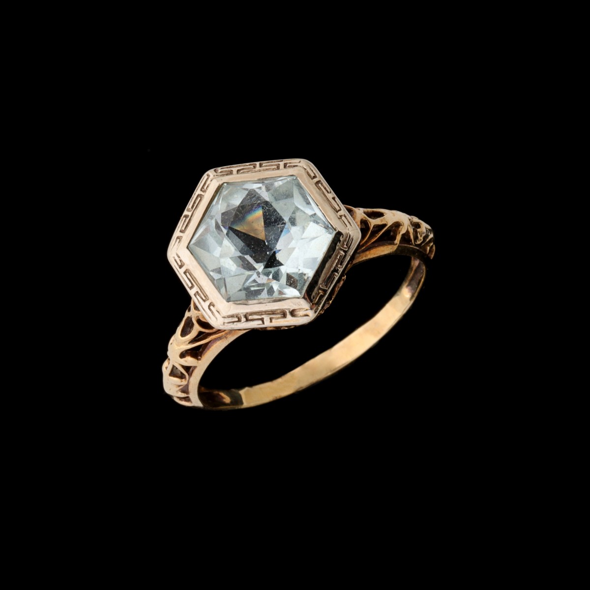 AN UNMARKED GOLD FILIGREE RING WITH FACETED STONE