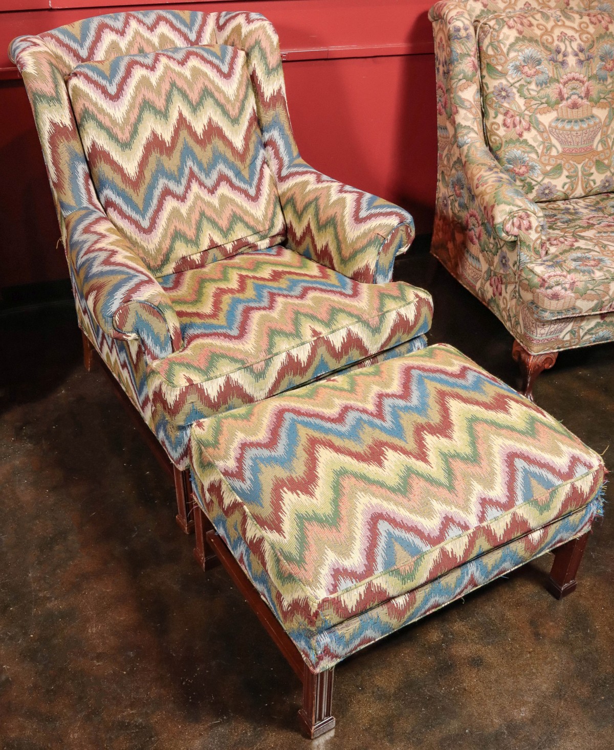 A CHAIR AND OTTOMAN IN FLAMESTITCH FABRIC WITH WEAR